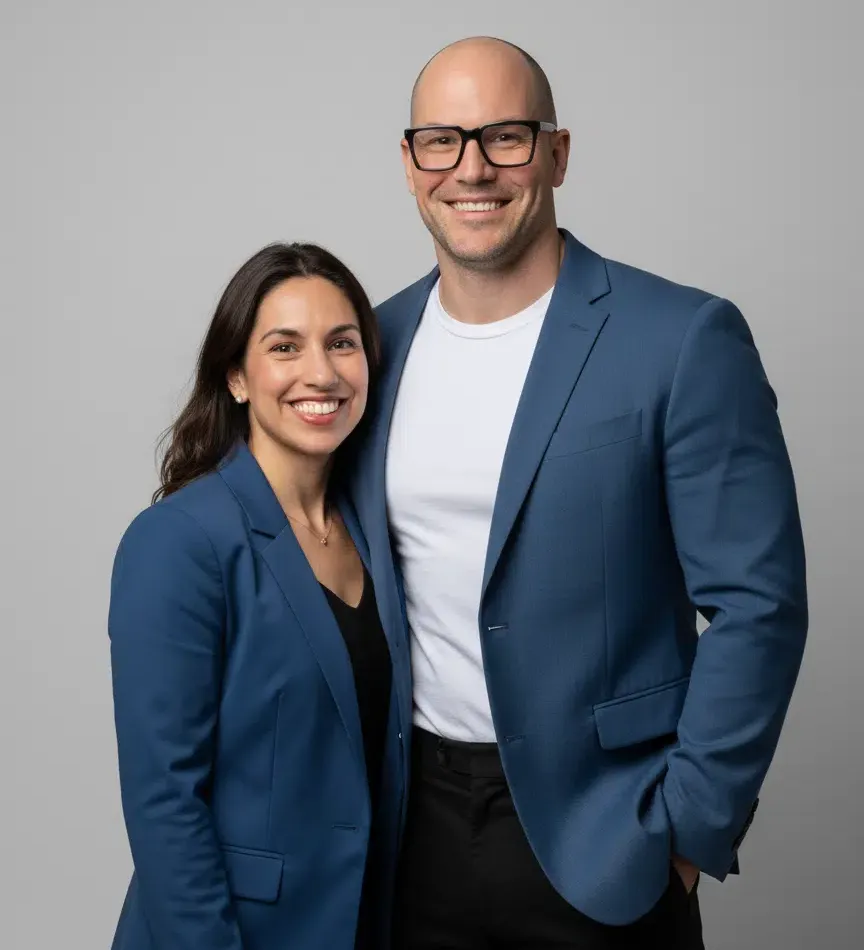 John Andrew Williams and Amois Williams, co-founders of CTEDU and Coach Theory, standing together in matching navy blazers